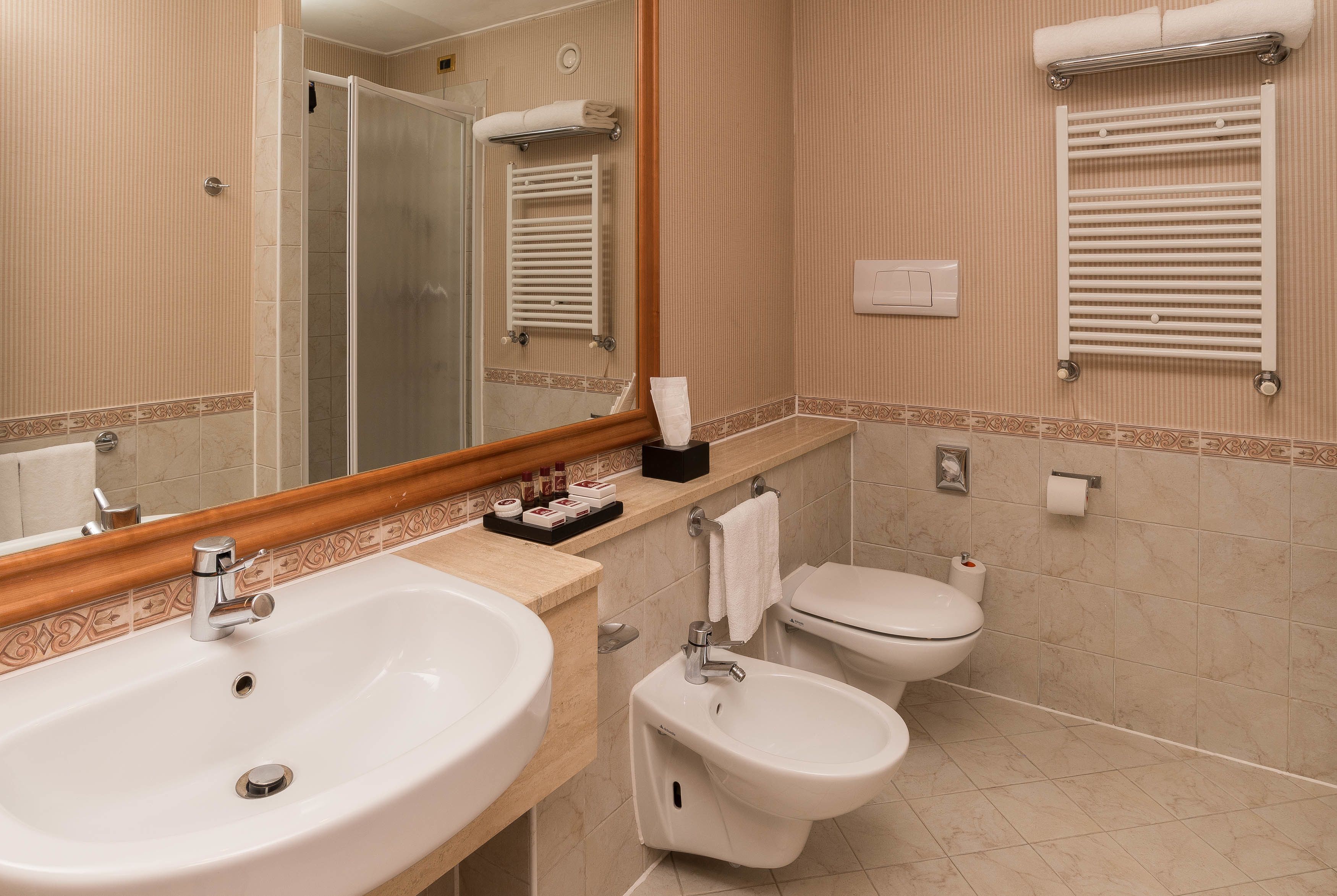 Ein Badezimmer mit Waschbecken, Bidet, Toilette und Handtuchhalter.