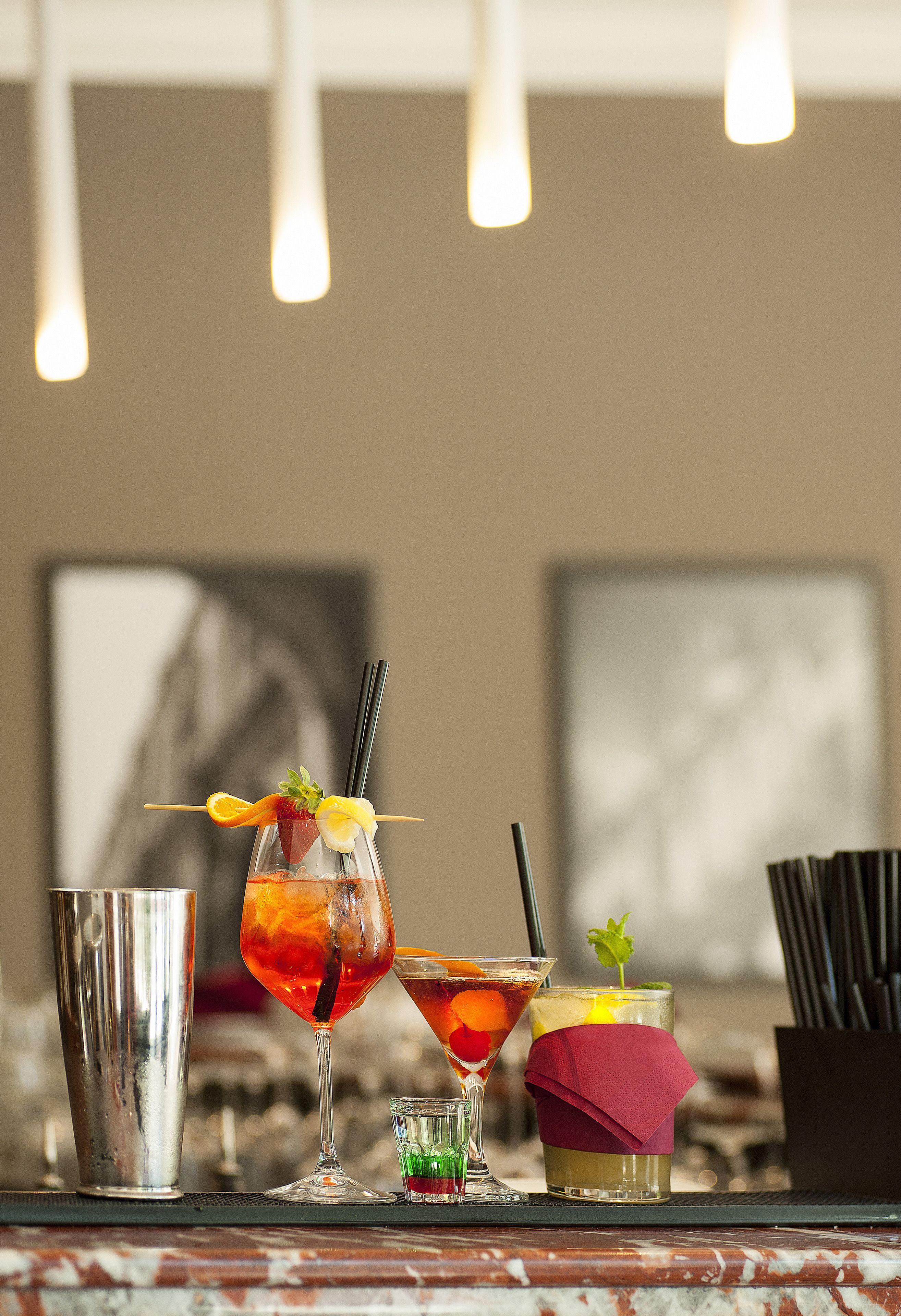A bar area with various drinks, a cocktail shaker, and a martini glass.
