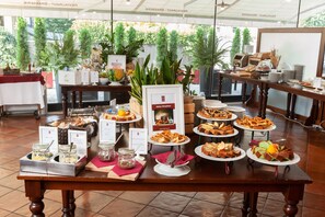 A buffet setup with various food items and a sign indicating 'Italian Breakfast'.