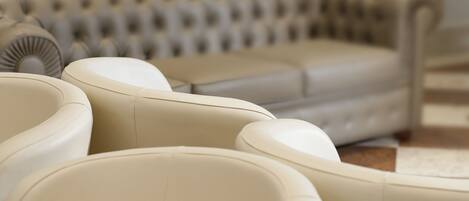 A beige sofa with a tufted backrest and a matching ottoman.