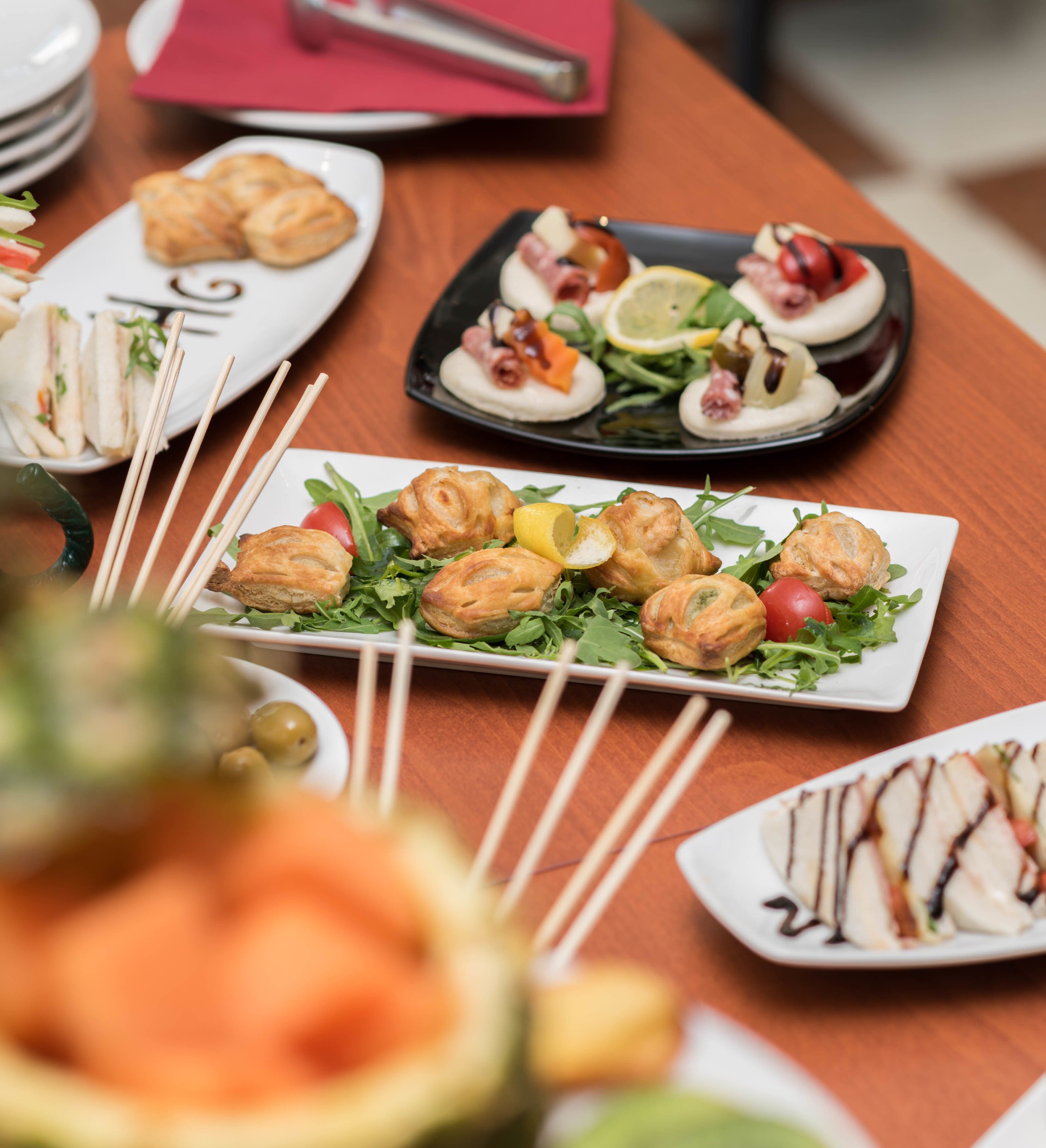 Variedad de platos sobre una mesa, incluyendo pasteles y ensaladas.