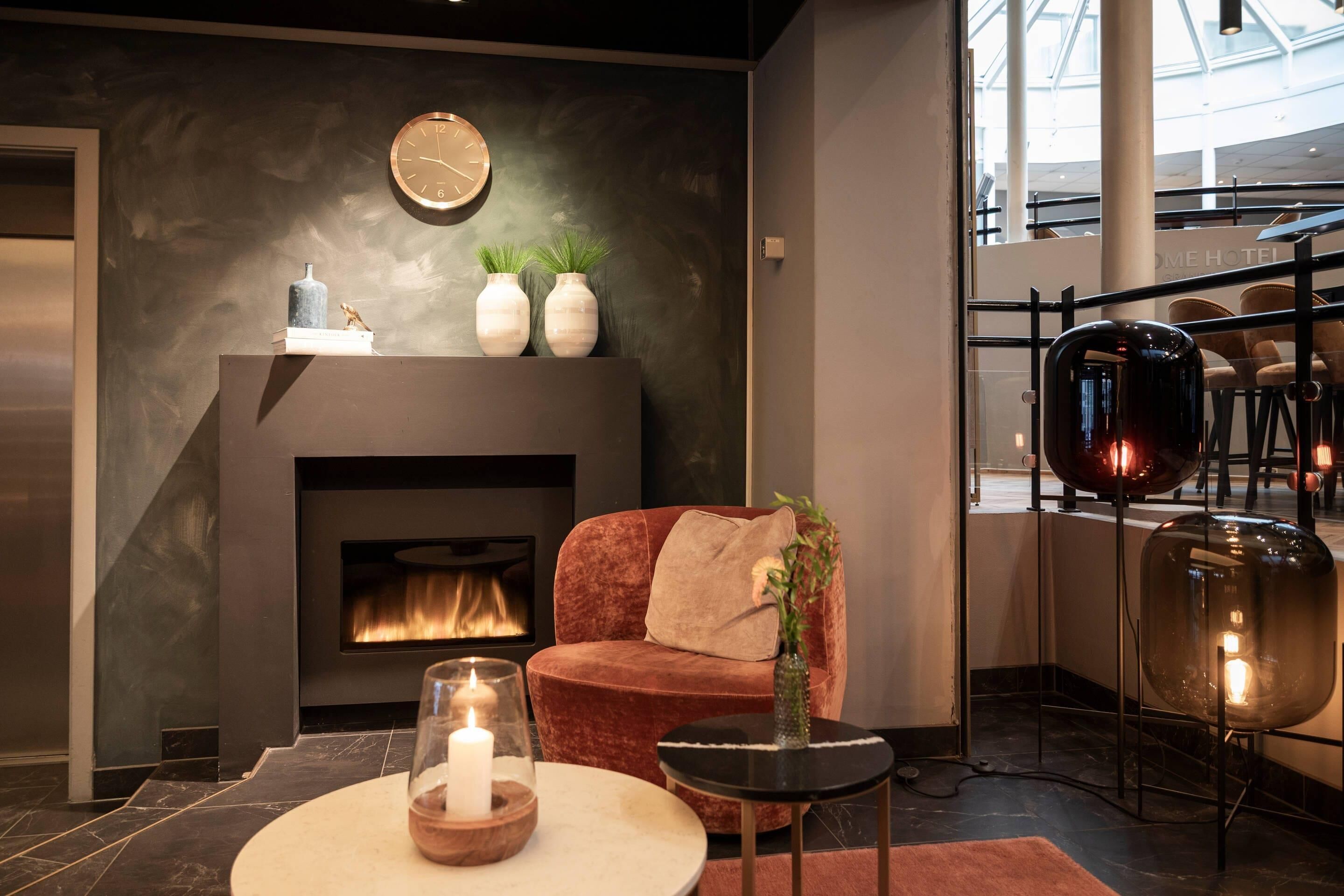 A modern living room with a fireplace, a sofa, a small table, and decorative vases.
