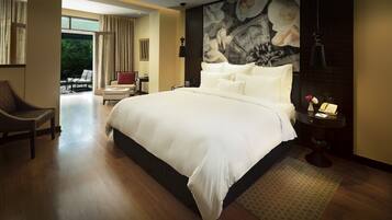 A spacious bedroom with a large bed, a desk, and a chair.