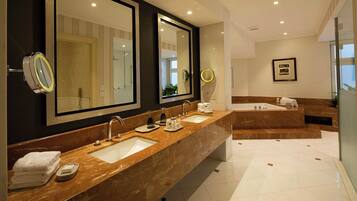 A modern bathroom with two sinks, large mirrors, and a separate shower area.