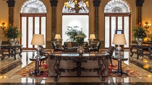 Eine prachtvolle Lobby mit Marmorboden, kunstvollen Möbeln und einer großen Kristallleuchter.