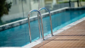 A swimming pool with metal railings and a wooden deck. - Premier Hotel Cape Town (Cape Town)