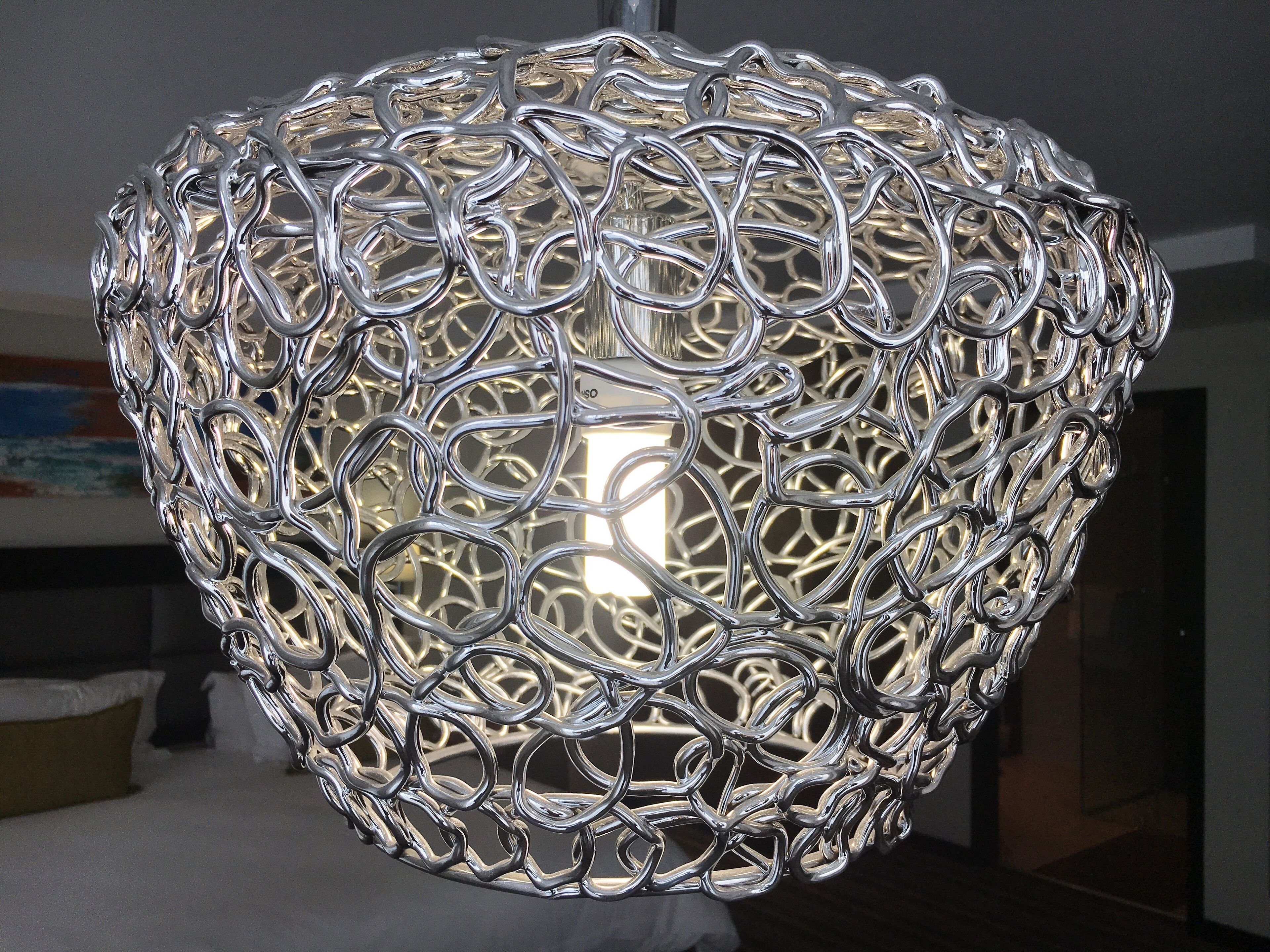 A metallic, intricately designed pendant light fixture.