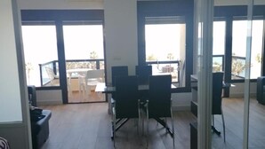 A spacious room with a dining area, large windows, and a view of the outdoors. - Aloha Playa (BENALMADENA)