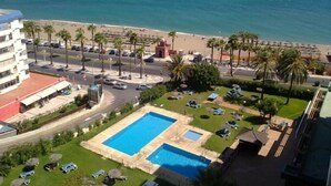 A hotel with a pool, beach view, and palm trees. - Aloha Playa (BENALMADENA)