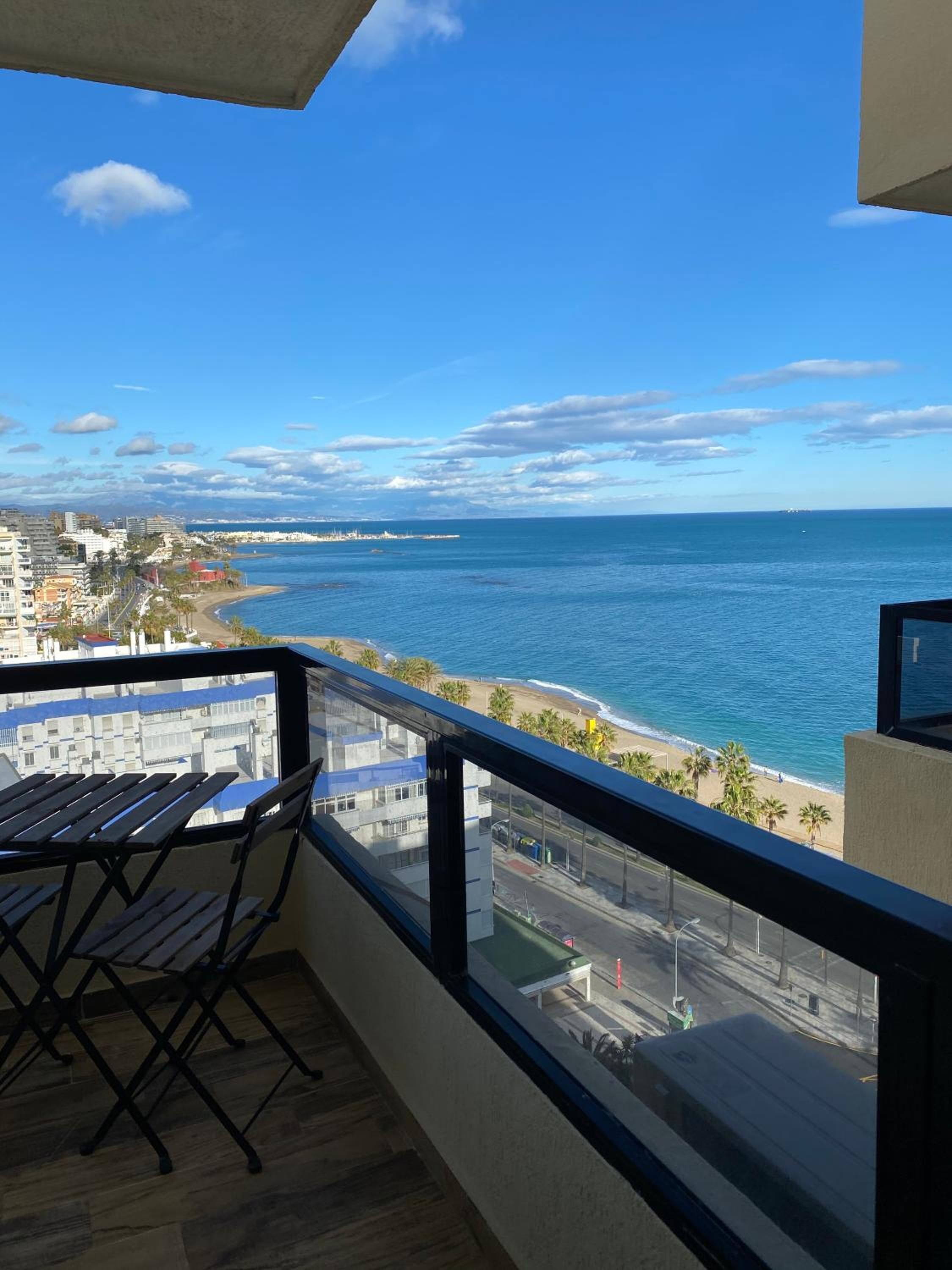 Ein Balkon mit Blick auf den Ozean und den Strand.