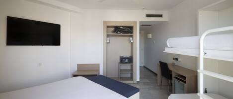 A modern hotel room with a single bed, a desk, a chair, and a bunk bed.