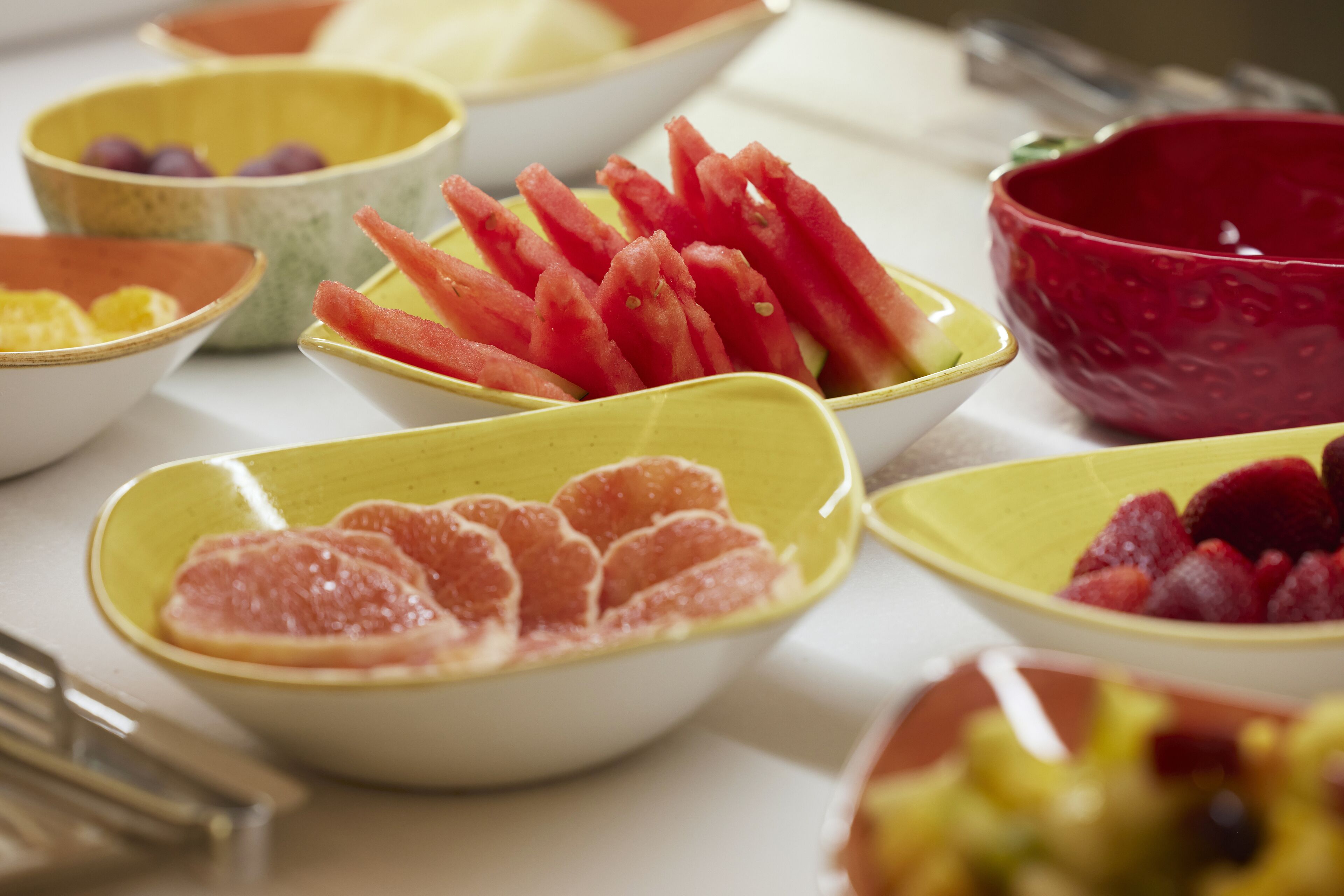 Ein Tisch mit verschiedenen Schalen, gefüllt mit Obst.