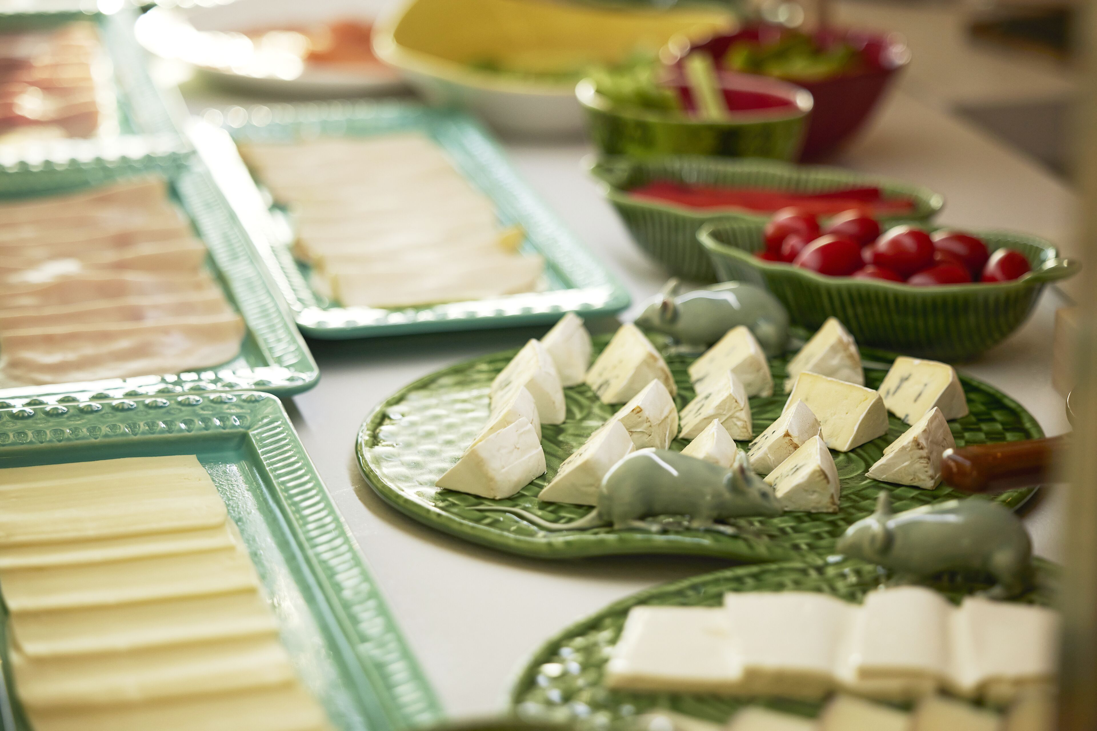 Een buffet met diverse soorten eten, waaronder kaas, fruit en groenten.