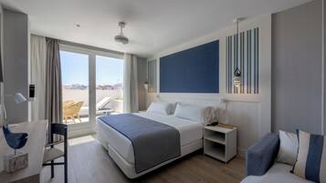Habitación de hotel moderna con una cama grande, un escritorio y una silla. Se ve la ciudad a través de la ventana.