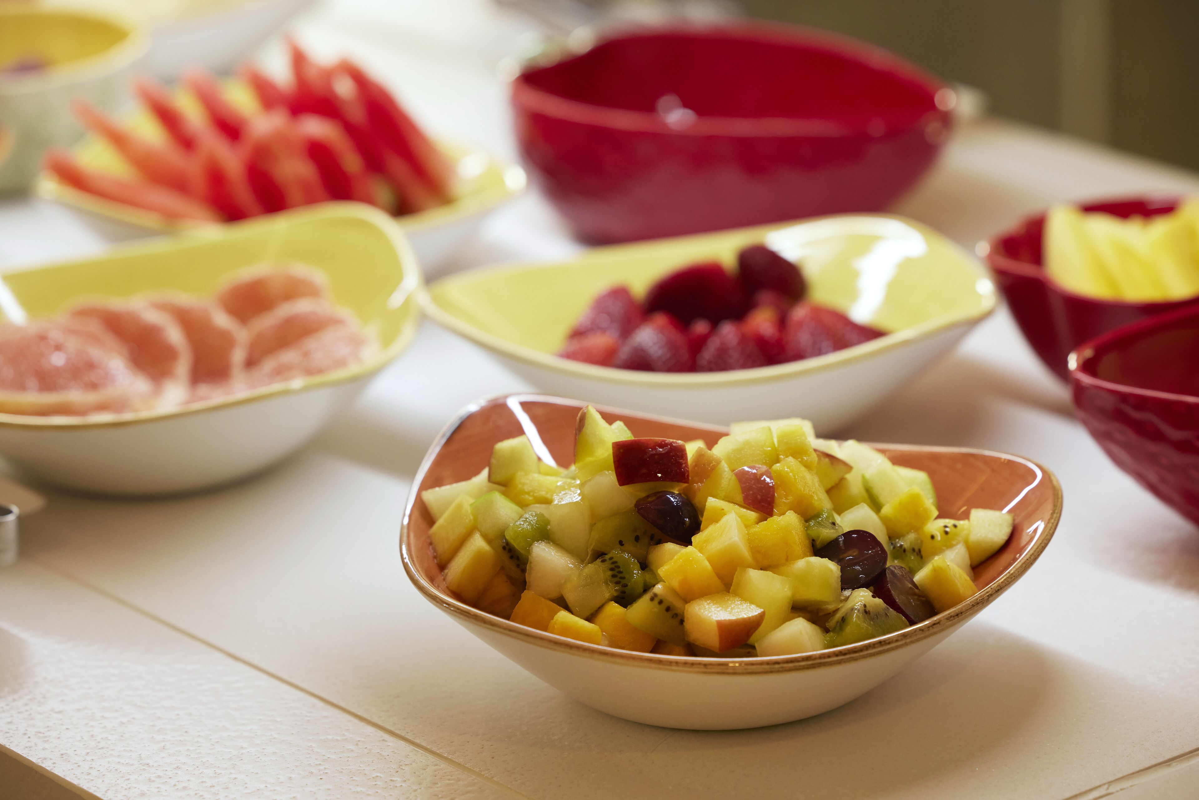 Een tafel met meerdere schalen vol verschillende soorten fruit.