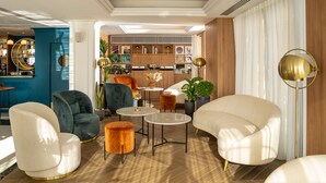 A modern living room with a bar area, featuring a mix of contemporary and classic furniture, including a white sofa, a blue armchair, and a round coffee table. - Ocean Drive Ibiza (Ibiza Town)