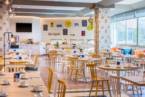 Enjoy a casual dining experience surrounded by communal tables and a central bar area.