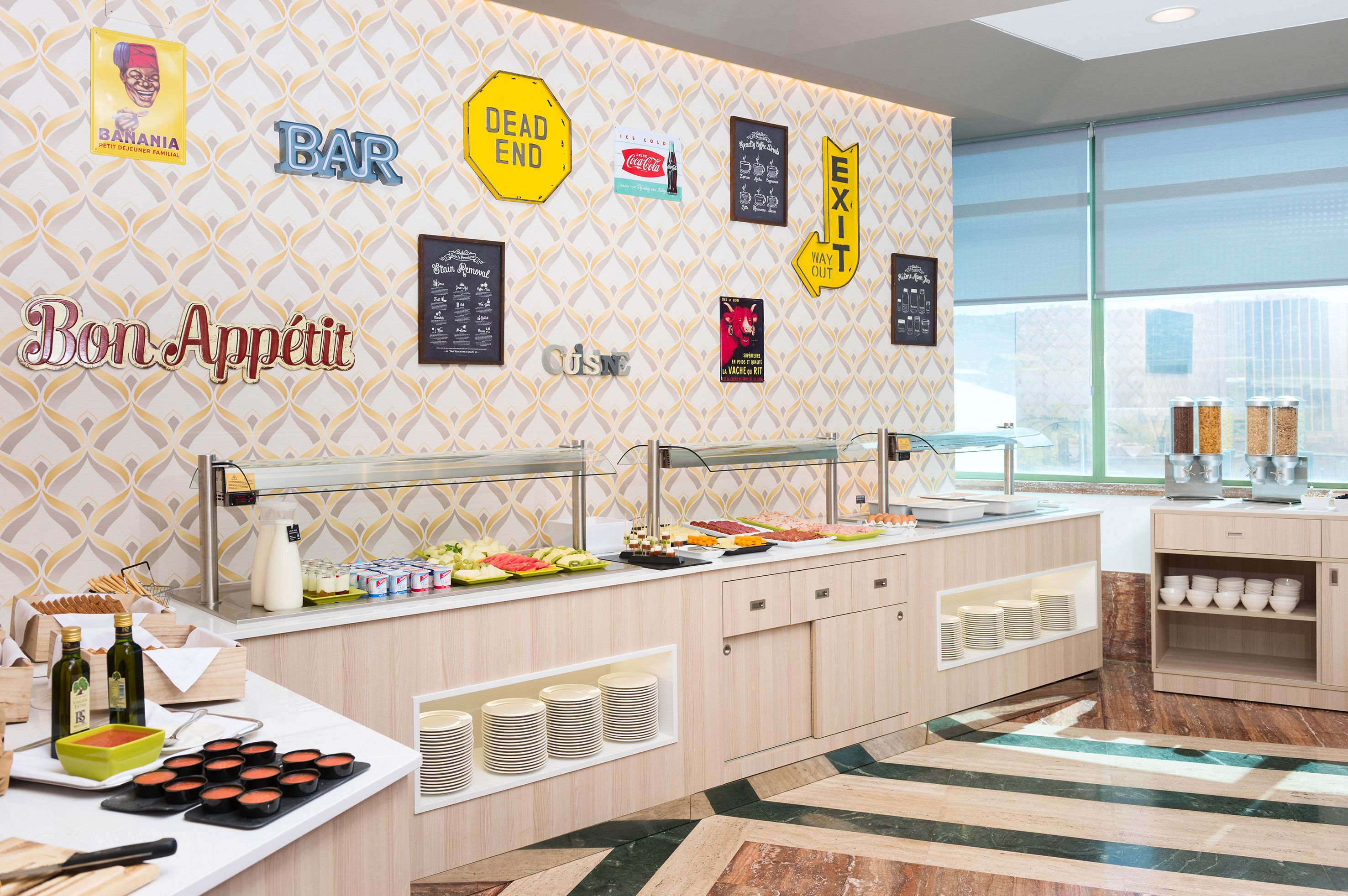 A buffet area with various food options, a bar sign, and exit signs on the wall.
