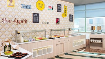 A buffet area with various food options, a bar sign, and exit signs on the wall.