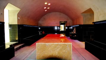Un interior espacioso y moderno con una plataforma rectangular central, techos altos y una paleta de colores cálidos.
