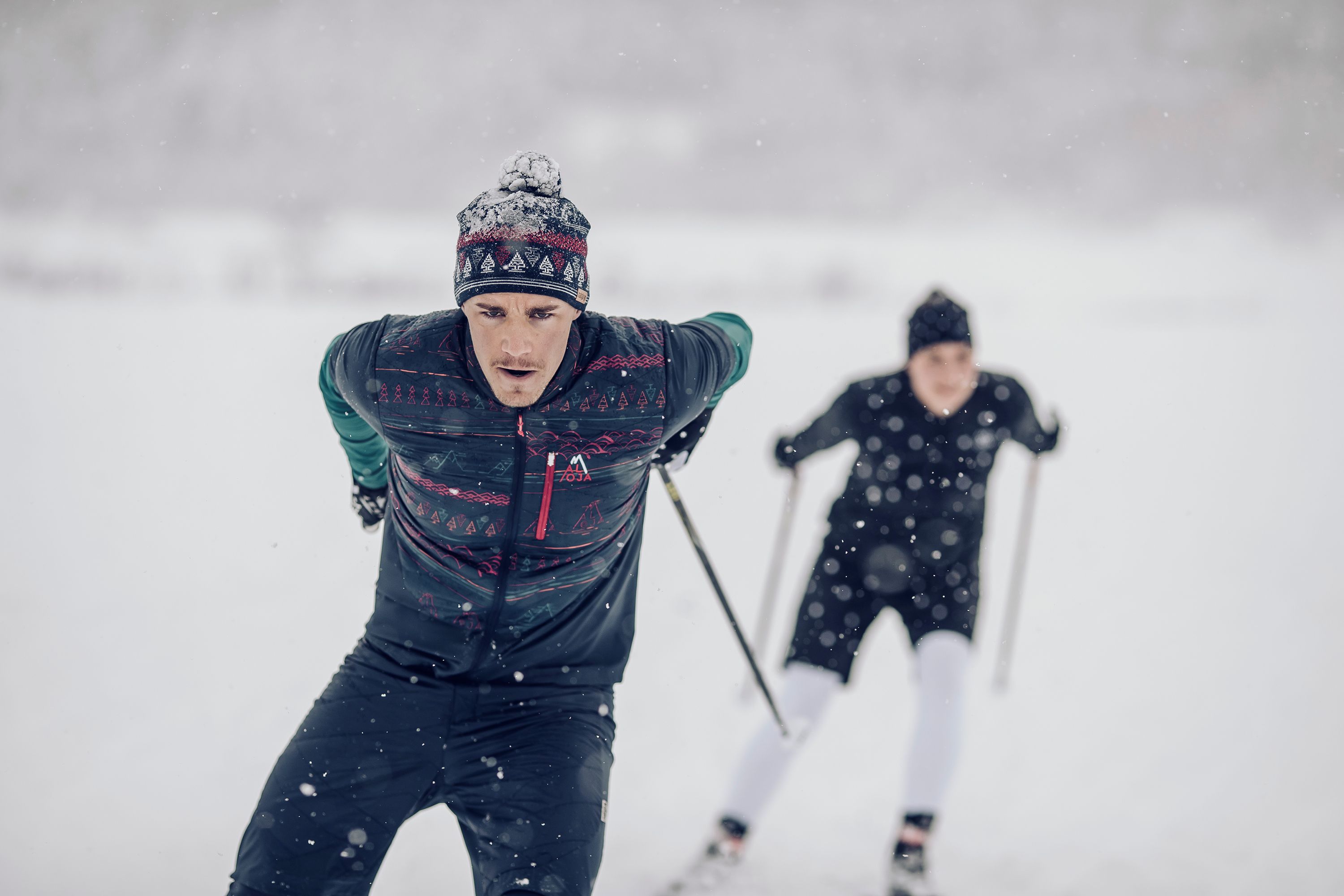 Two individuals skiing in a snowy landscape.