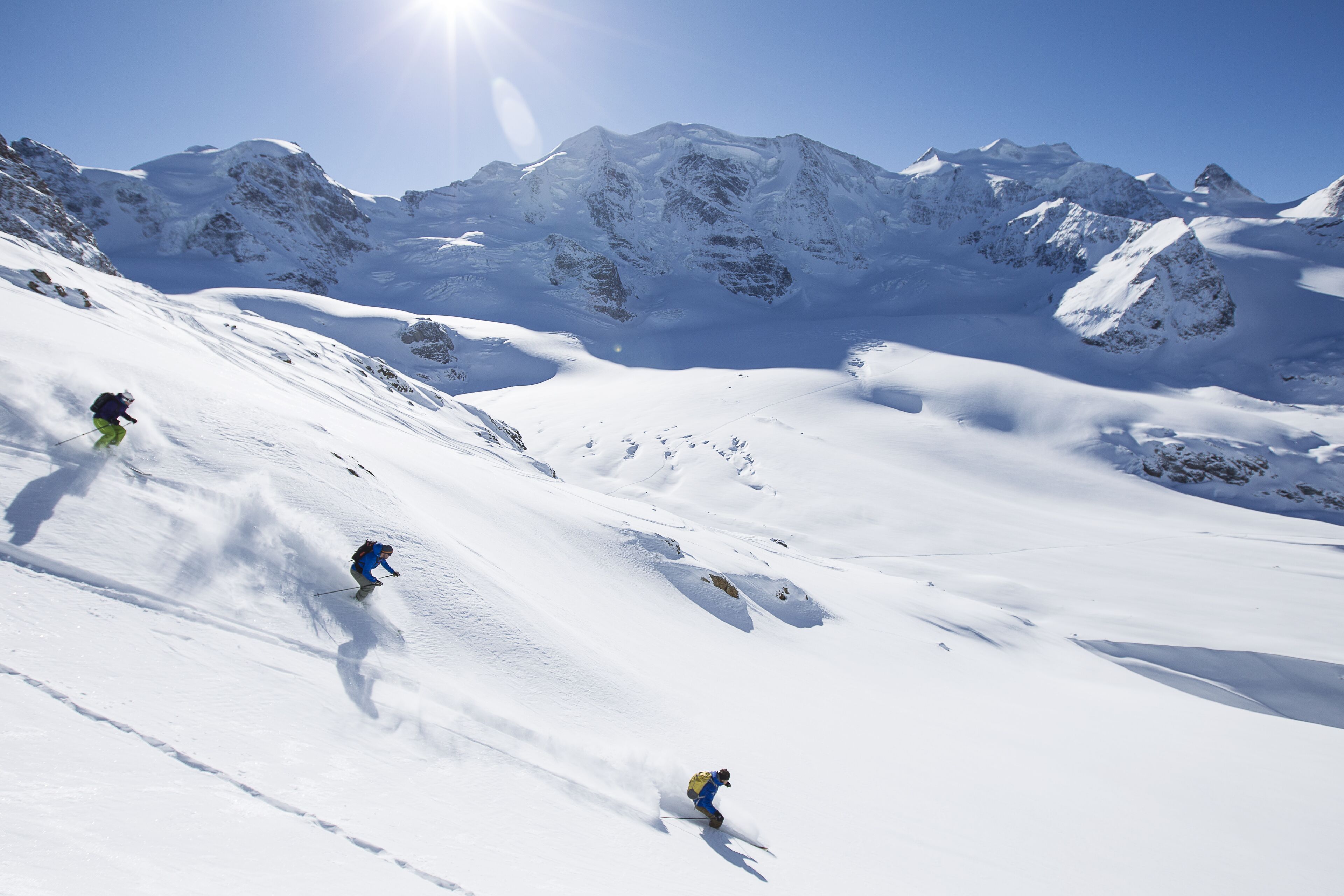 A snowy mountain landscape with skiers.