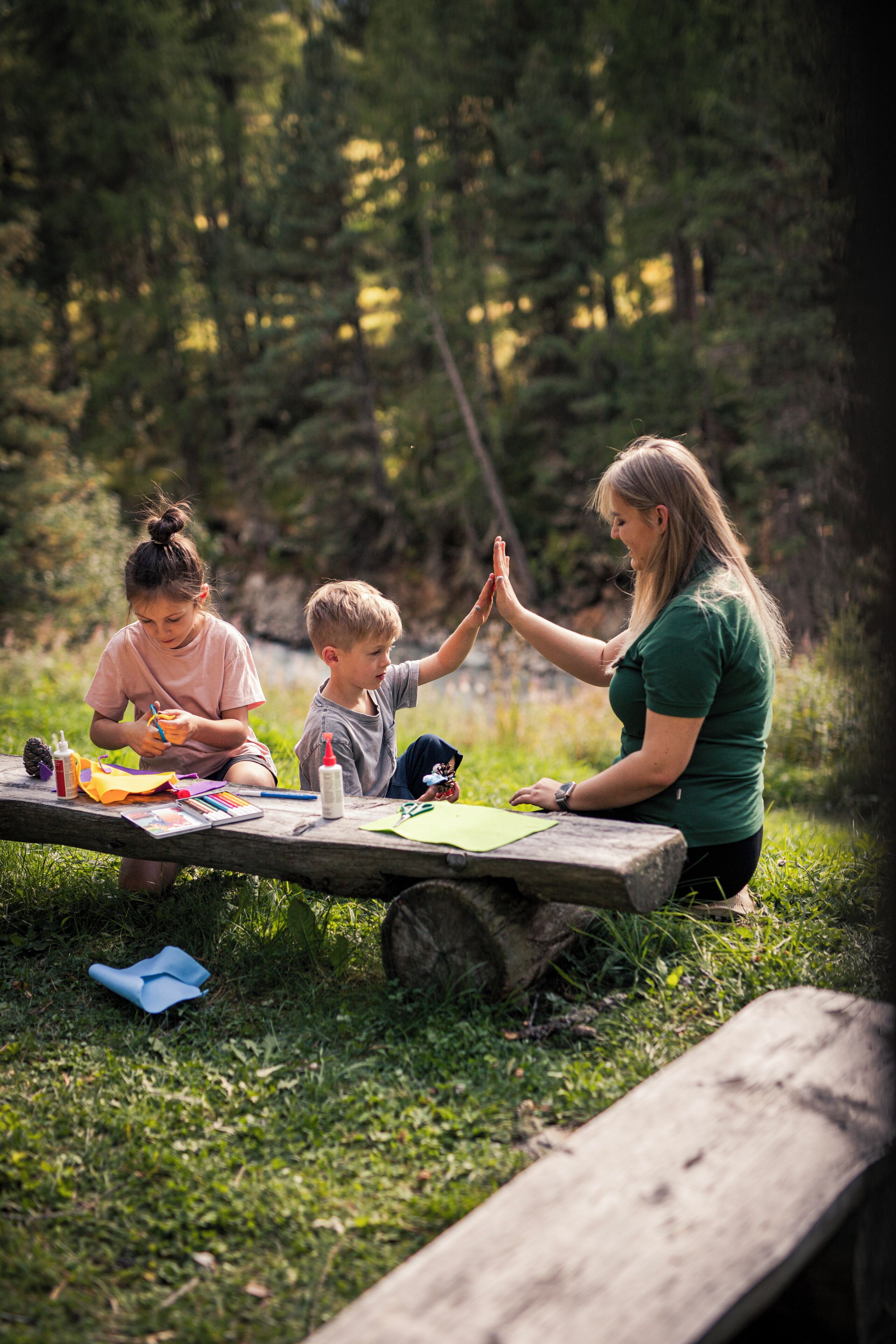 Ett picknickbord i trä med målarutrustning och två personer som ger varandra en high-five.