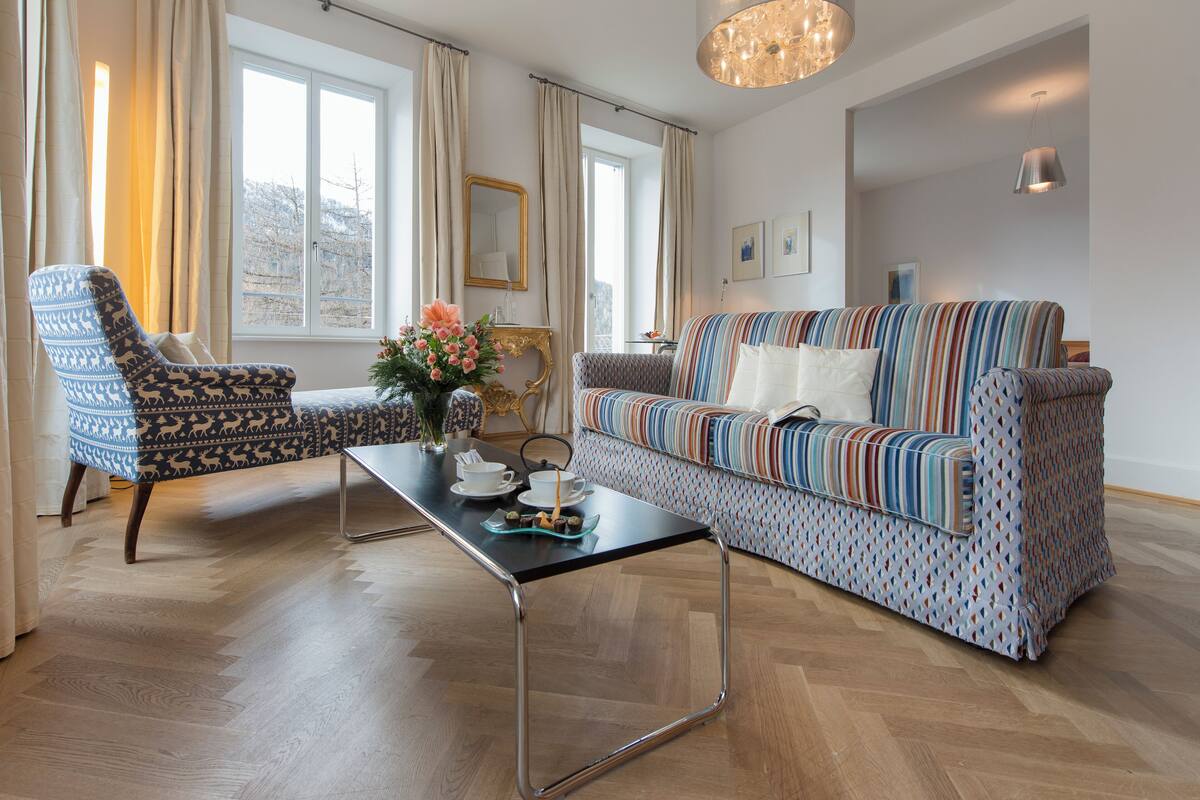 A modern living room with a sofa, armchair, and a coffee table.