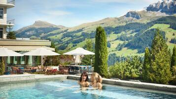 Relax by the serene pool surrounded by outdoor seating and breathtaking mountain views.