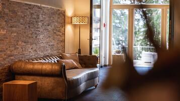 A cozy room with a leather sofa, a wooden side table, and a floor lamp.