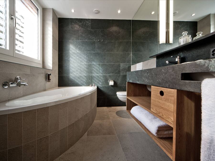 A modern bathroom with a freestanding bathtub, a wooden vanity, and a large mirror.