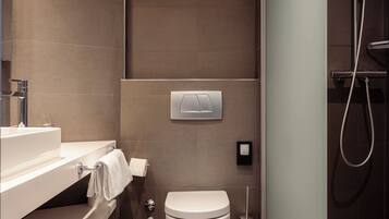 A modern bathroom with a toilet, sink, and shower.