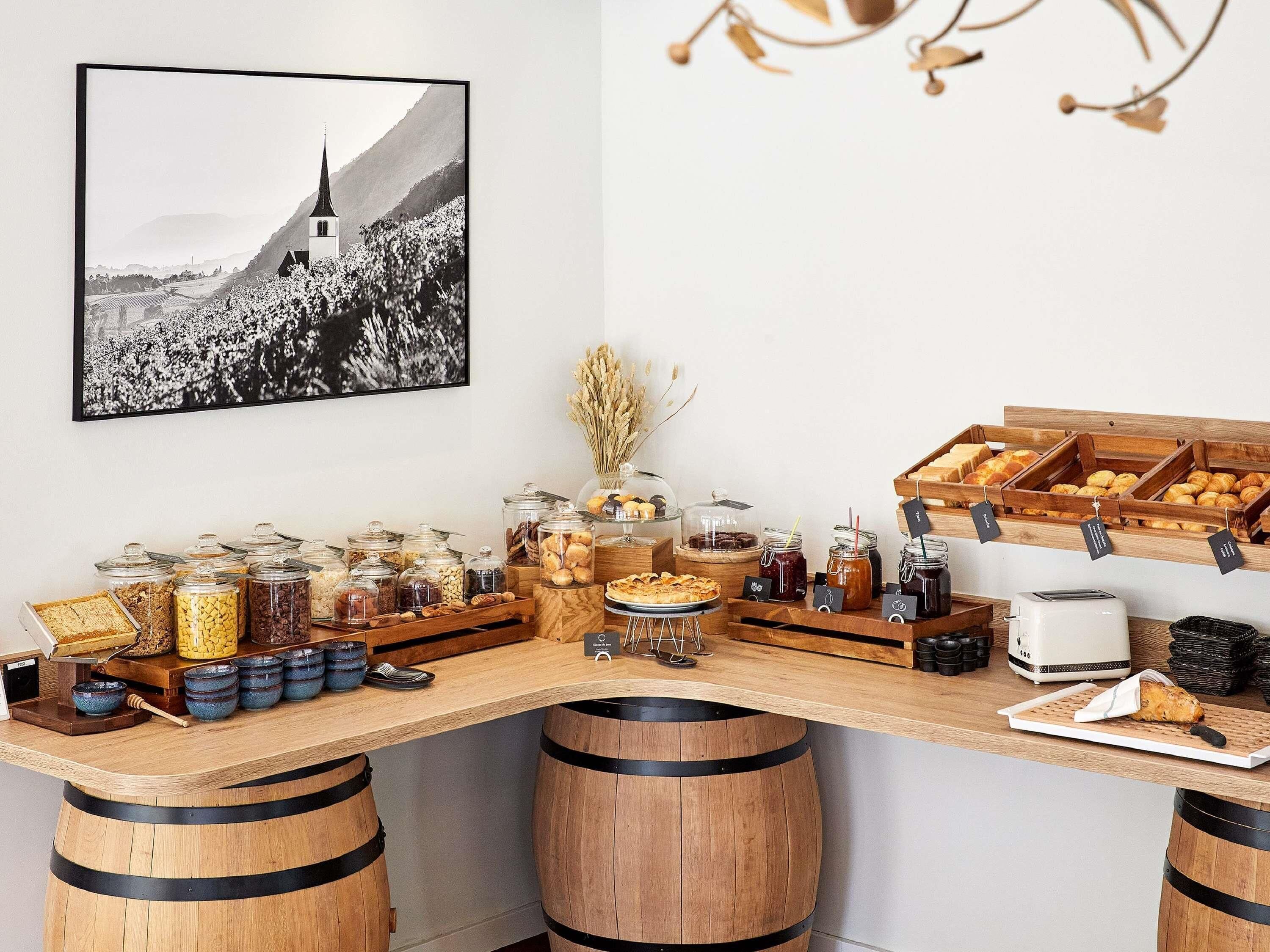 A breakfast buffet with various food items and a black and white photograph on the wall.