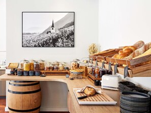 A breakfast buffet with various food items, a coffee machine, and a rustic wooden counter. - Mercure Plaza Biel (Biel)
