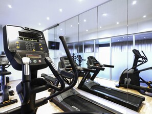 A modern gym with stationary bikes, treadmills, and a mirrored wall. - Mercure Plaza Biel (Biel)