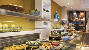 A buffet with various dishes, including seafood, salads, and bread.