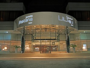 A modern hotel entrance with glass doors and a covered walkway. - Jumeira Rotana (Dubai)
