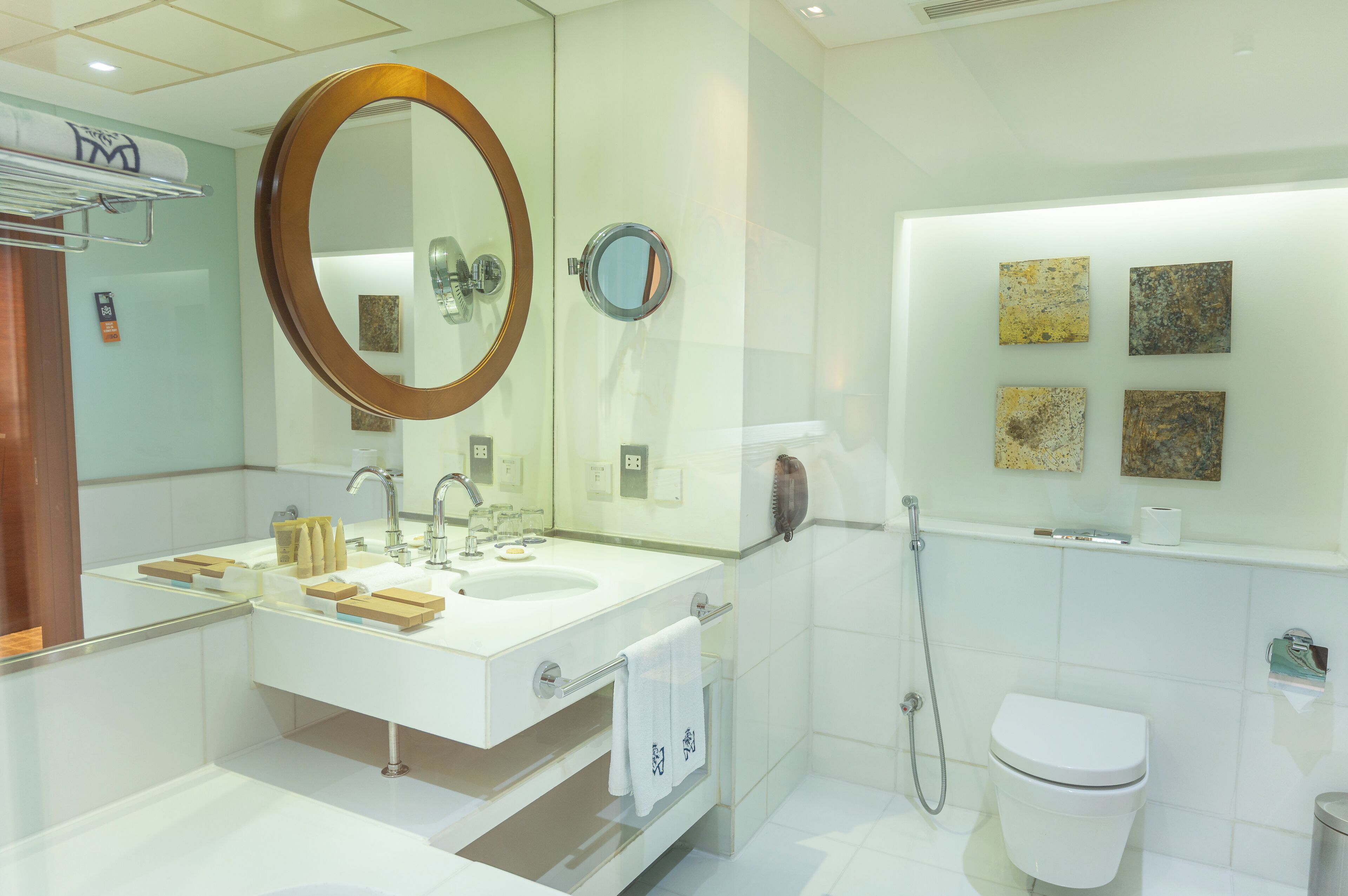 Een moderne badkamer met een grote spiegel, een wastafel, toilet en douche.