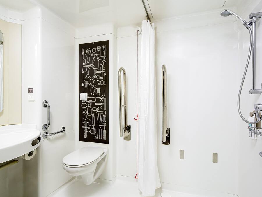 Een moderne badkamer met toilet, wastafel en douche.