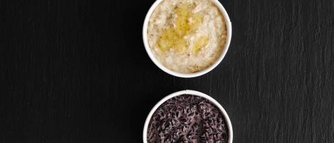 Tres tazones de avena con distintos ingredientes sobre una superficie oscura.
