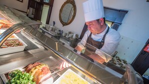 A buffet counter with various food items, including a large piece of meat, salads, and other dishes. - Salutation Hotel (Perth)