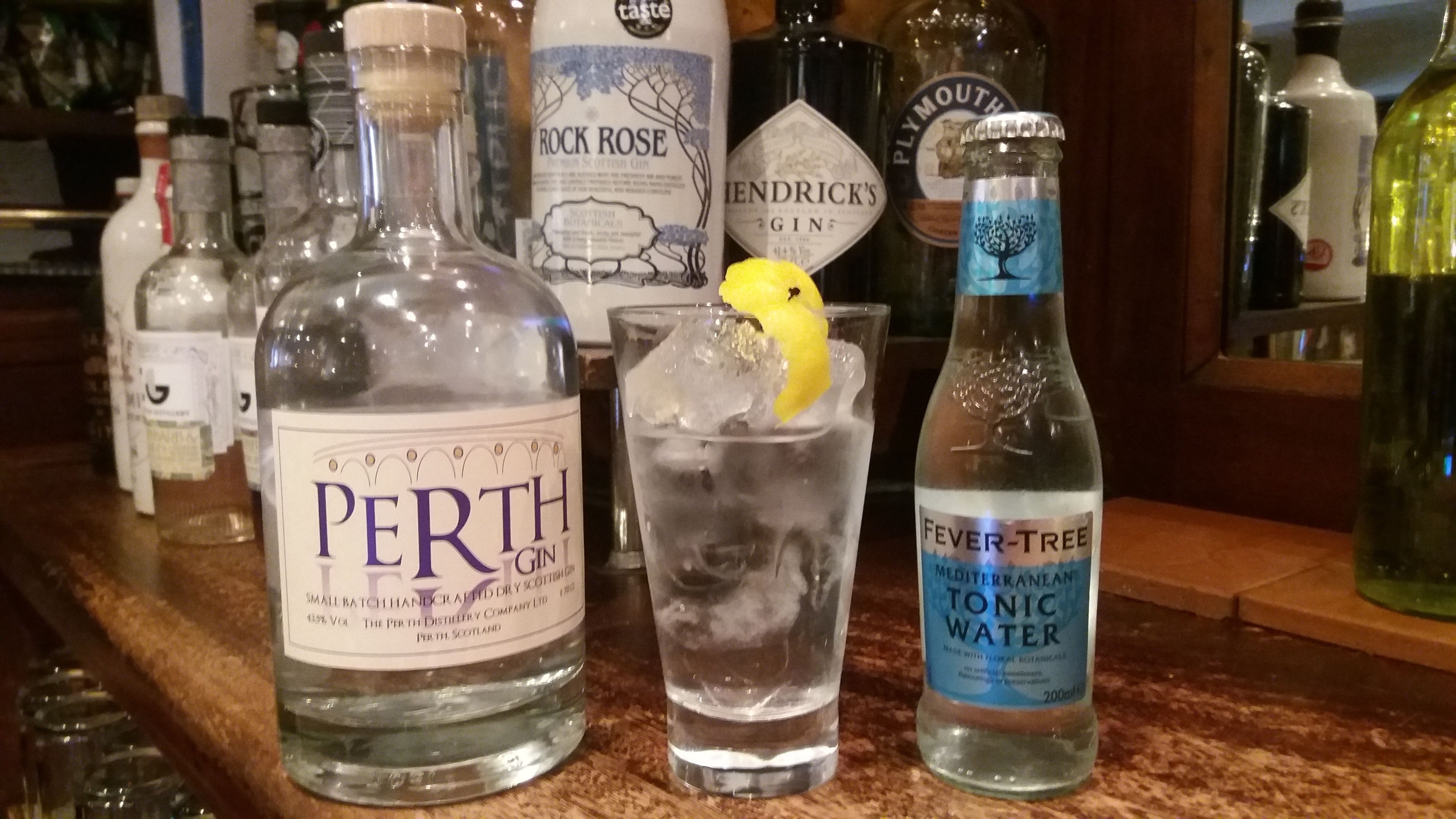 A bar counter with various bottles of gin and tonic water, including brands like Perth Gin and Fever-Tree.