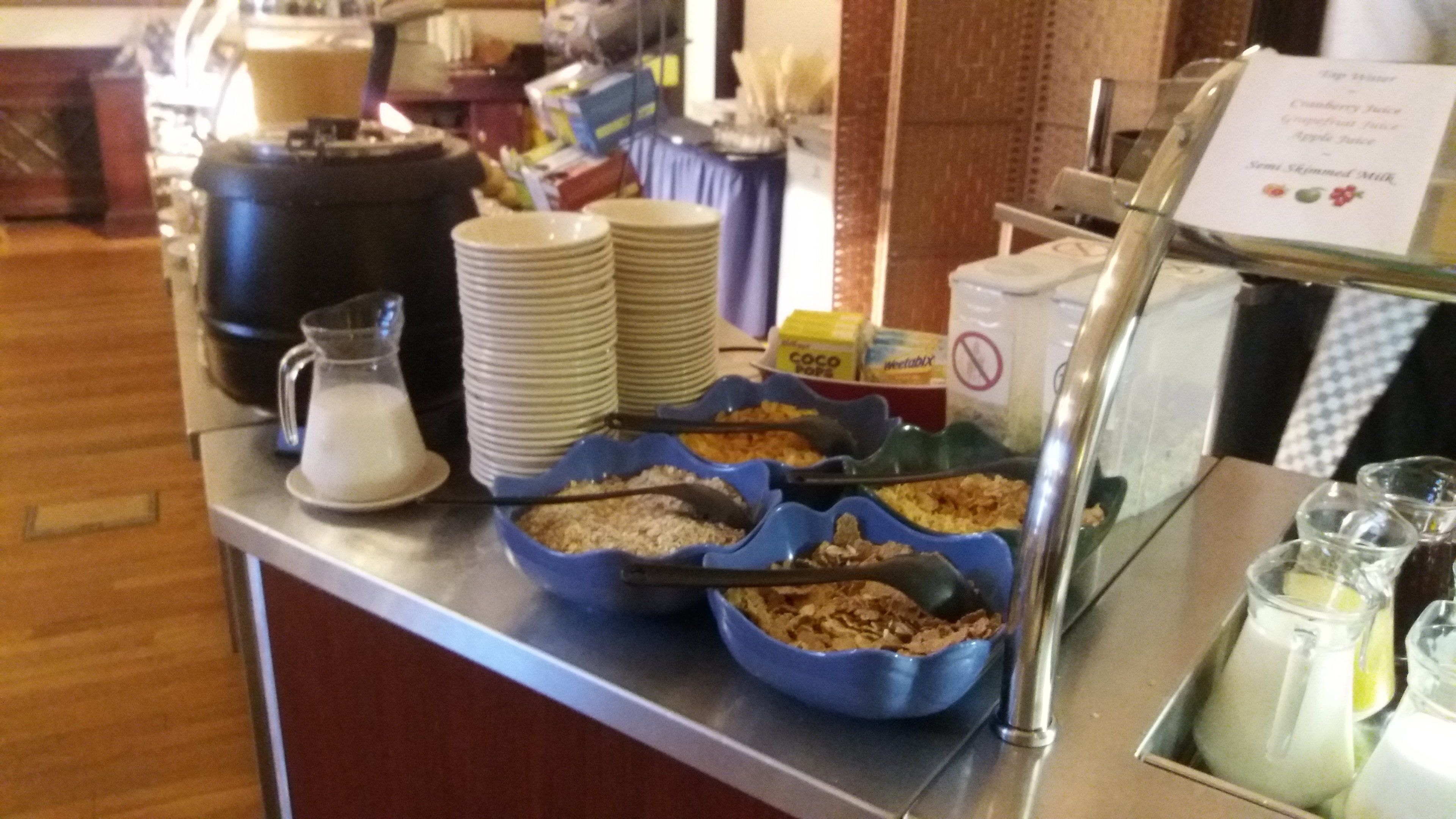 A buffet setup with various food items and a coffee station.