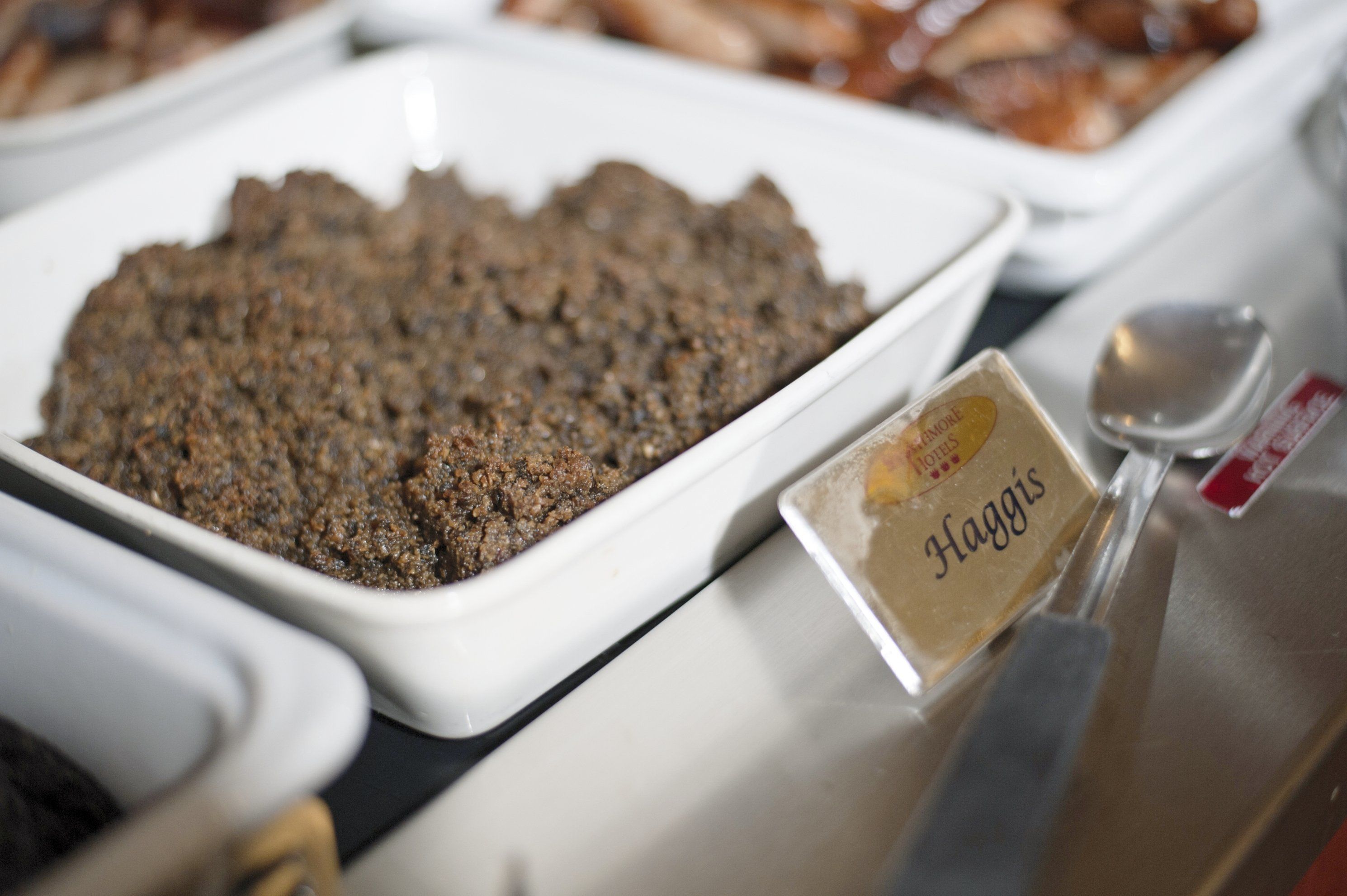 Un bufé con una variedad de platos, incluyendo un plato destacado con la etiqueta 'Haggis'.