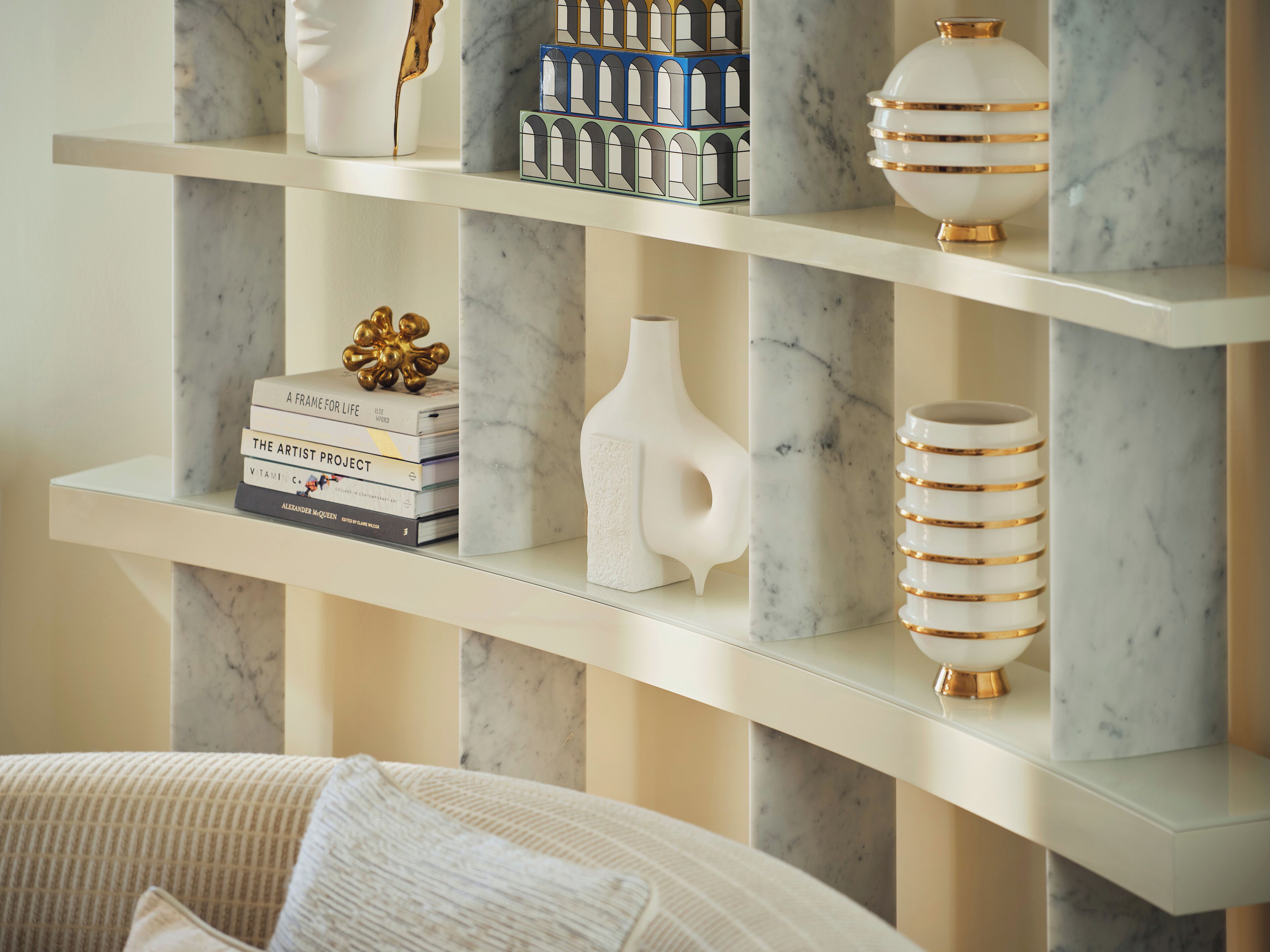 A marble shelf with decorative items including books, a vase, and a spherical object.
