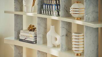 A marble shelf with decorative items including books, a vase, and a spherical object.