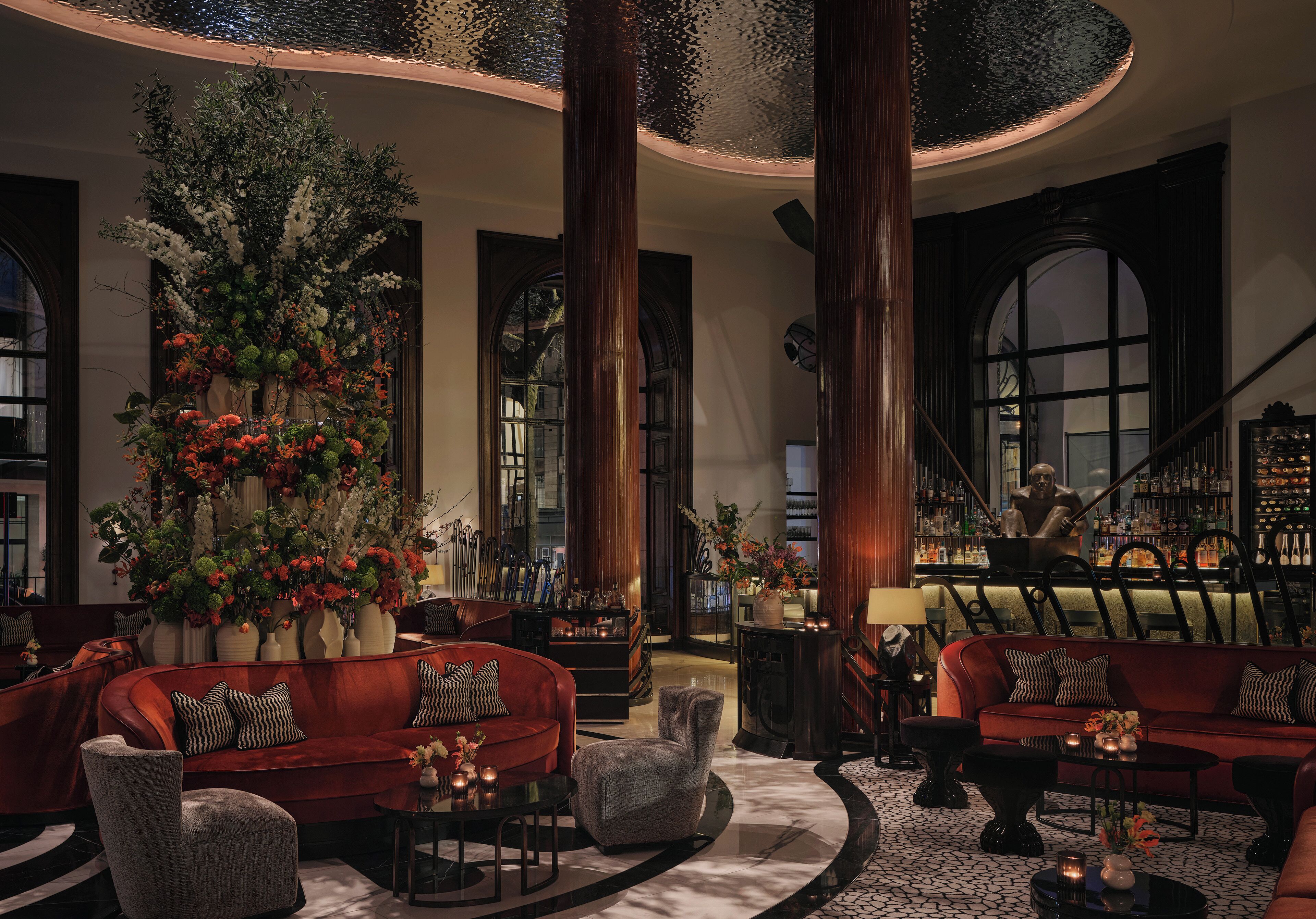 A lobby with a bar area, seating arrangements, and a staircase.