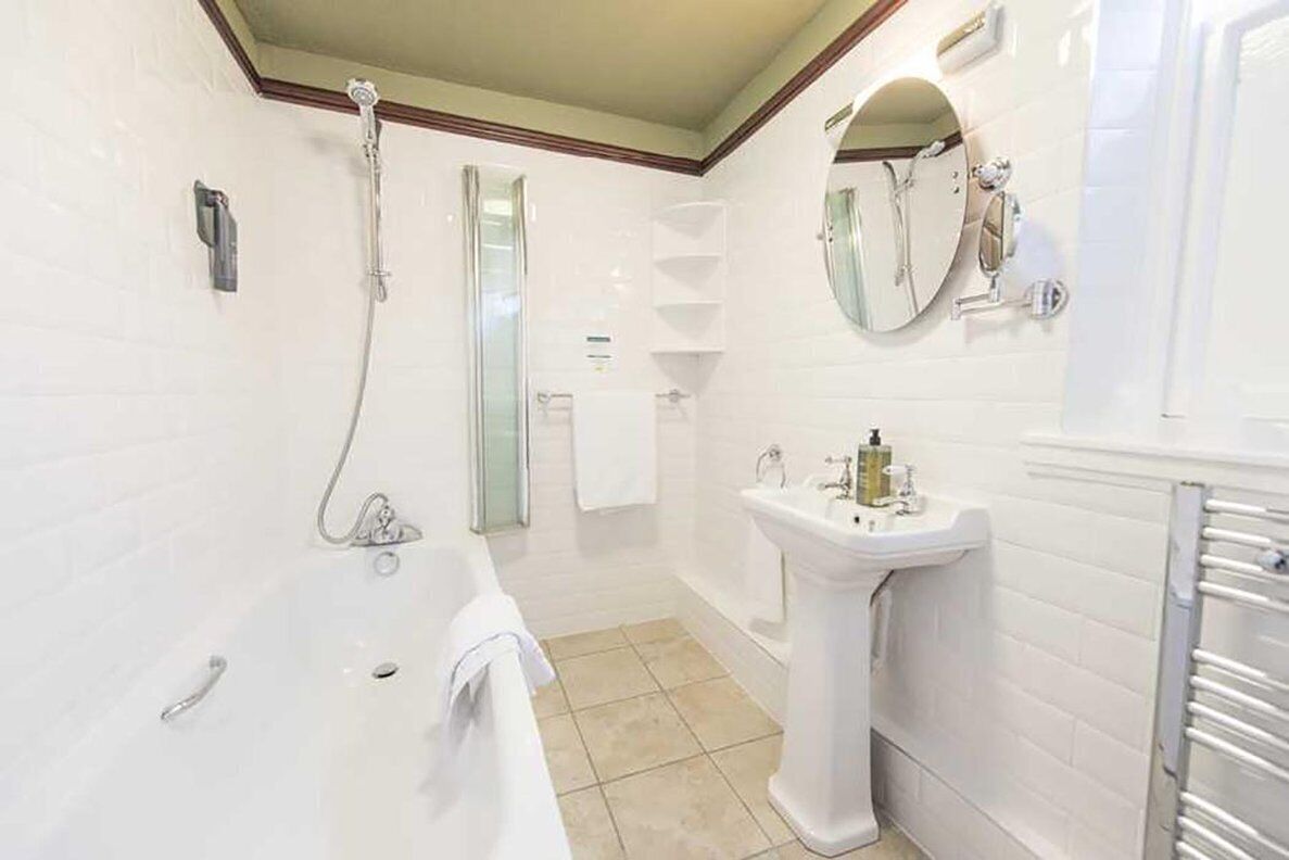 Ein modernes Badezimmer mit Badewanne, Waschtisch und Dusche.
