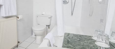 A modern bathroom with a toilet, bidet, and bathtub.
