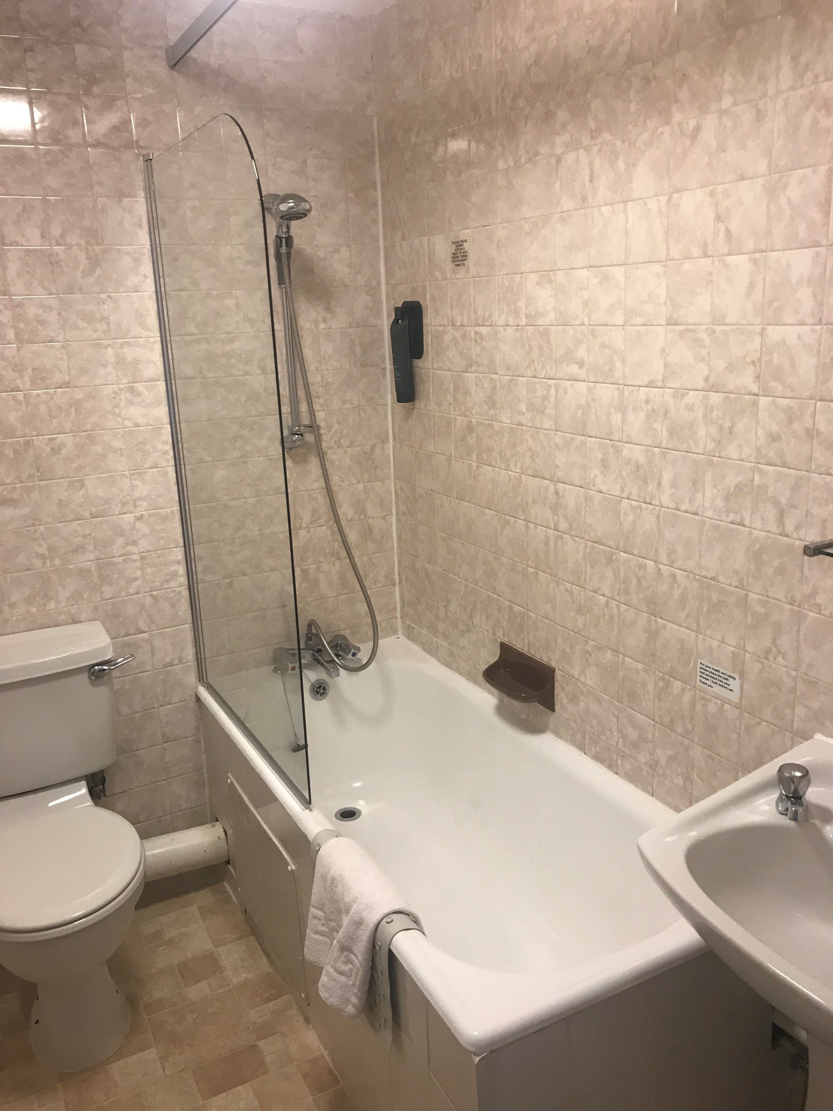 Ein Badezimmer mit einer gläsernen Duschkabine, einer Toilette und einem Waschbecken.